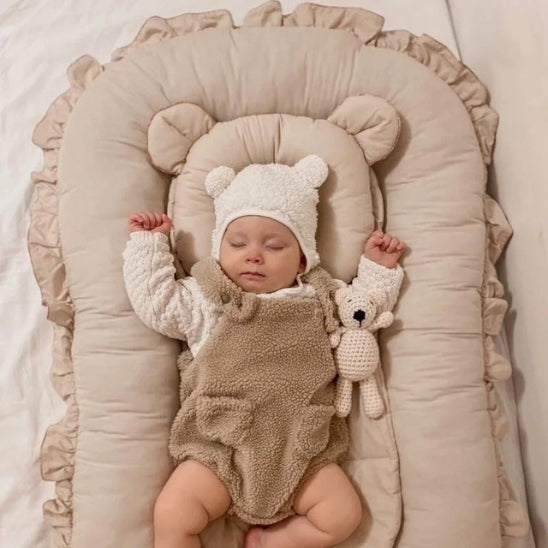 Bébé dormant dans un réducteur de lit bébé sécurisant