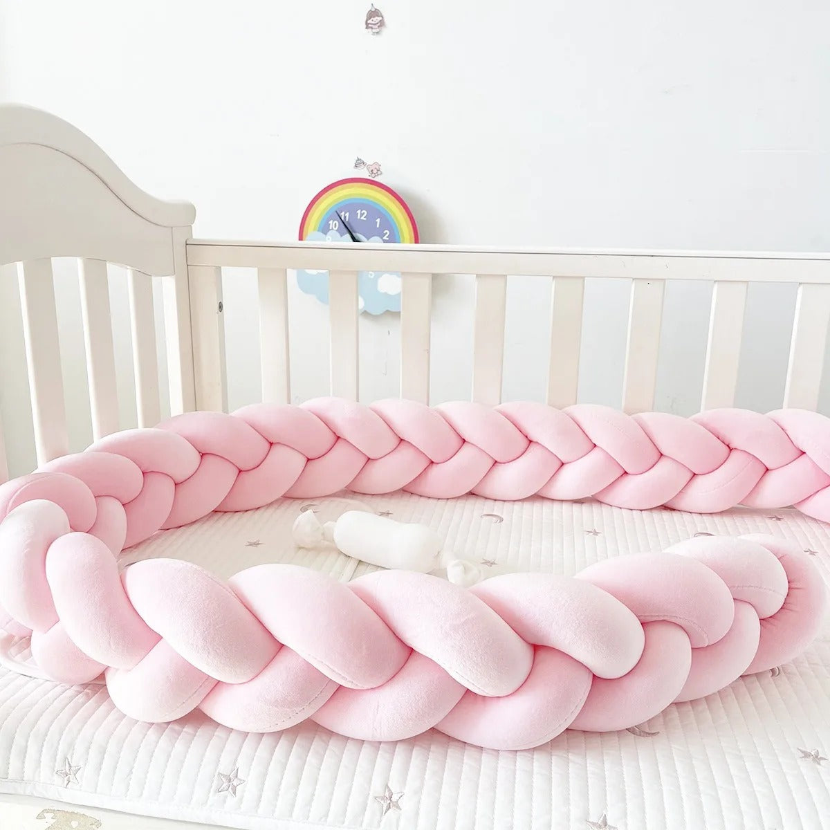 Tour de lit tressé rose gros plan dans lit barreaux