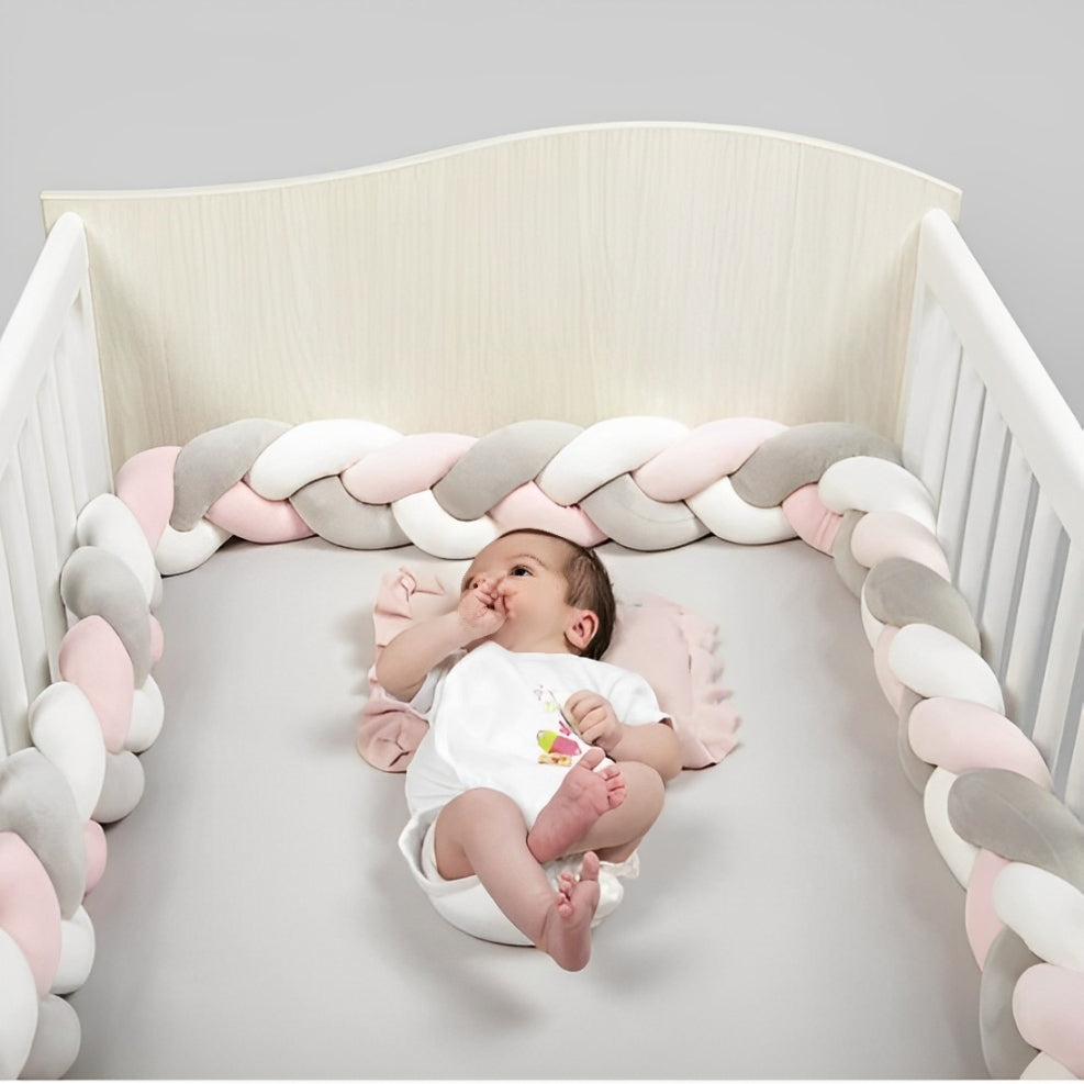 Tresse de lit rose, gris et blanc, douce et sécurisante, protégeant bébé dans un lit à barreaux