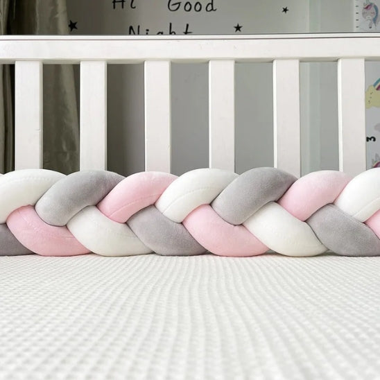 Zoom sur la tresse de lit bébé à 3 brins rose, gris et blanc, texture douce et rembourrage moelleux