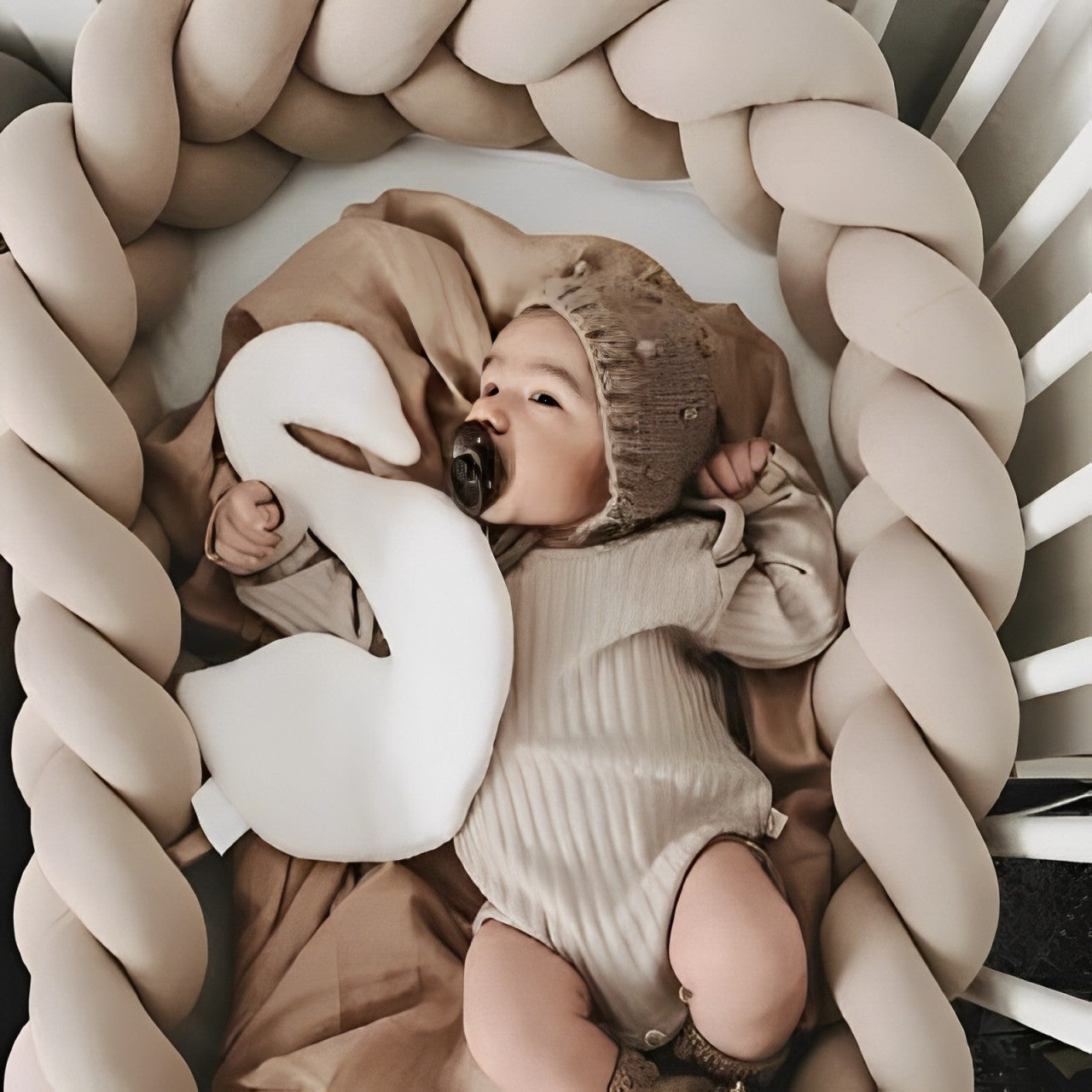 Tresse de lit beige universelle offrant une protection respirante et douce autour d’un bébé dans un lit à barreaux