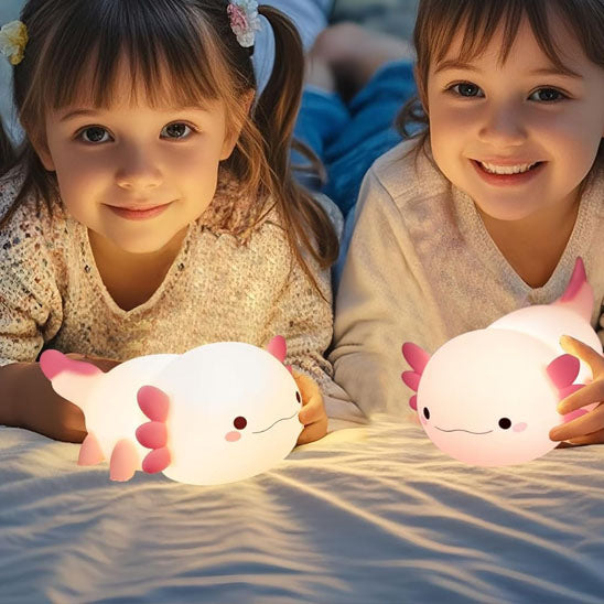veilleuse de nuit rose dans les mains de deux petites filles allongees sur lit