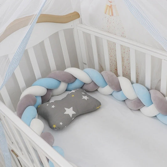 Tresse de lit bleu, blanc et gris pour garçon, installée le long d’un lit à barreaux, respirante et sécurisante pour le sommeil de bébé