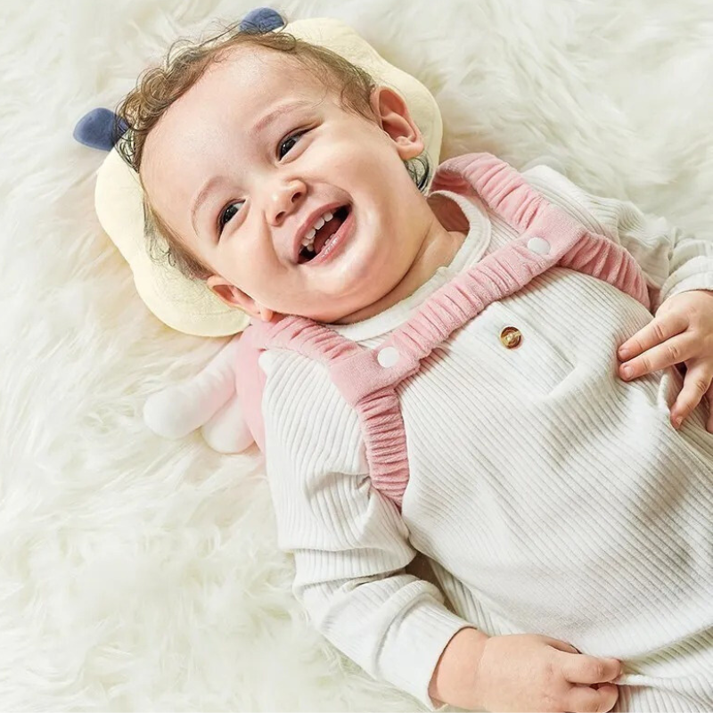 Bébé heureux avec coussin bebe ange protégeant tête et dos
