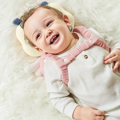 Bébé heureux avec coussin bebe ange protégeant tête et dos