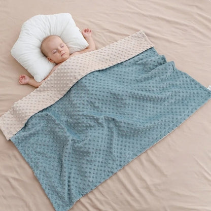 Couverture bebe beige et bleu sur bébé endormi