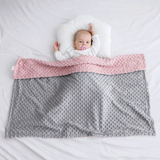 Couverture bebe plaid gris et rose sur bébé