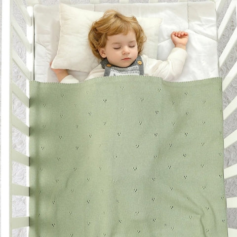 Couverture bebe tricot verte sur bébé endormi