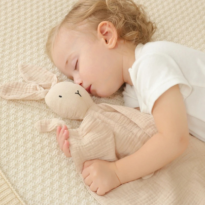 Doudou lapin dans les bras de bébé endormi