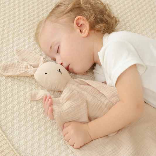 Doudou lapin dans les bras de bébé endormi