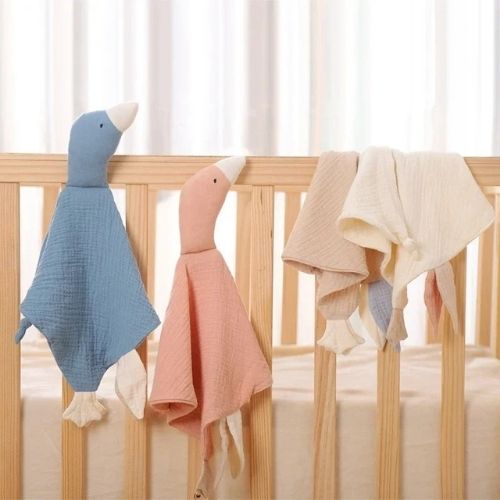 Doudou oie posé sur les barreaux du lit bébé
