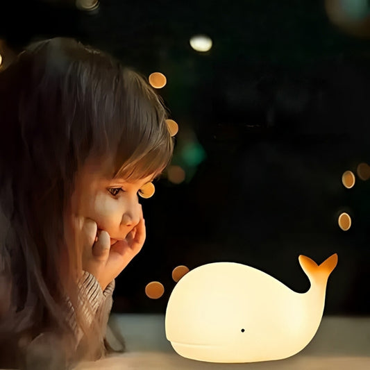Fillette regardant une veilleuse bébé LED forme baleine