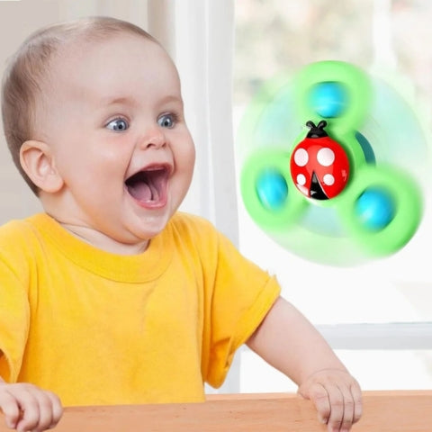 Enfant heureux joue avec jouet pour bébé toupie ventouse coccinelle