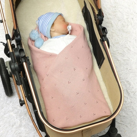 Couverture bebe tricot rose enveloppant un nouveau-né