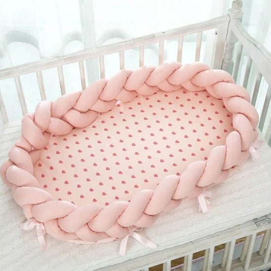 Reducteur de lit rose dans un lit à barreaux pour bébé