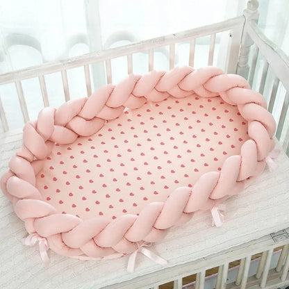 Reducteur de lit rose dans un lit à barreaux pour bébé