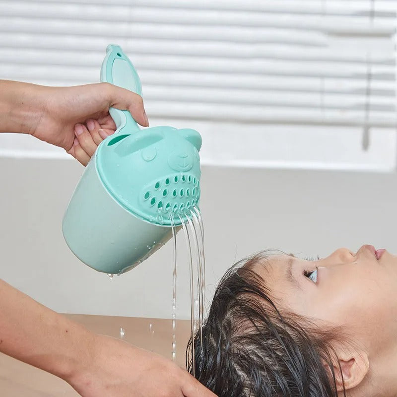 Rince tete bébé vert lavant les cheveux d’un enfant