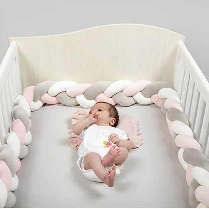 Tresse de lit rose, gris et blanc, douce et sécurisante, protégeant bébé dans un lit à barreaux

