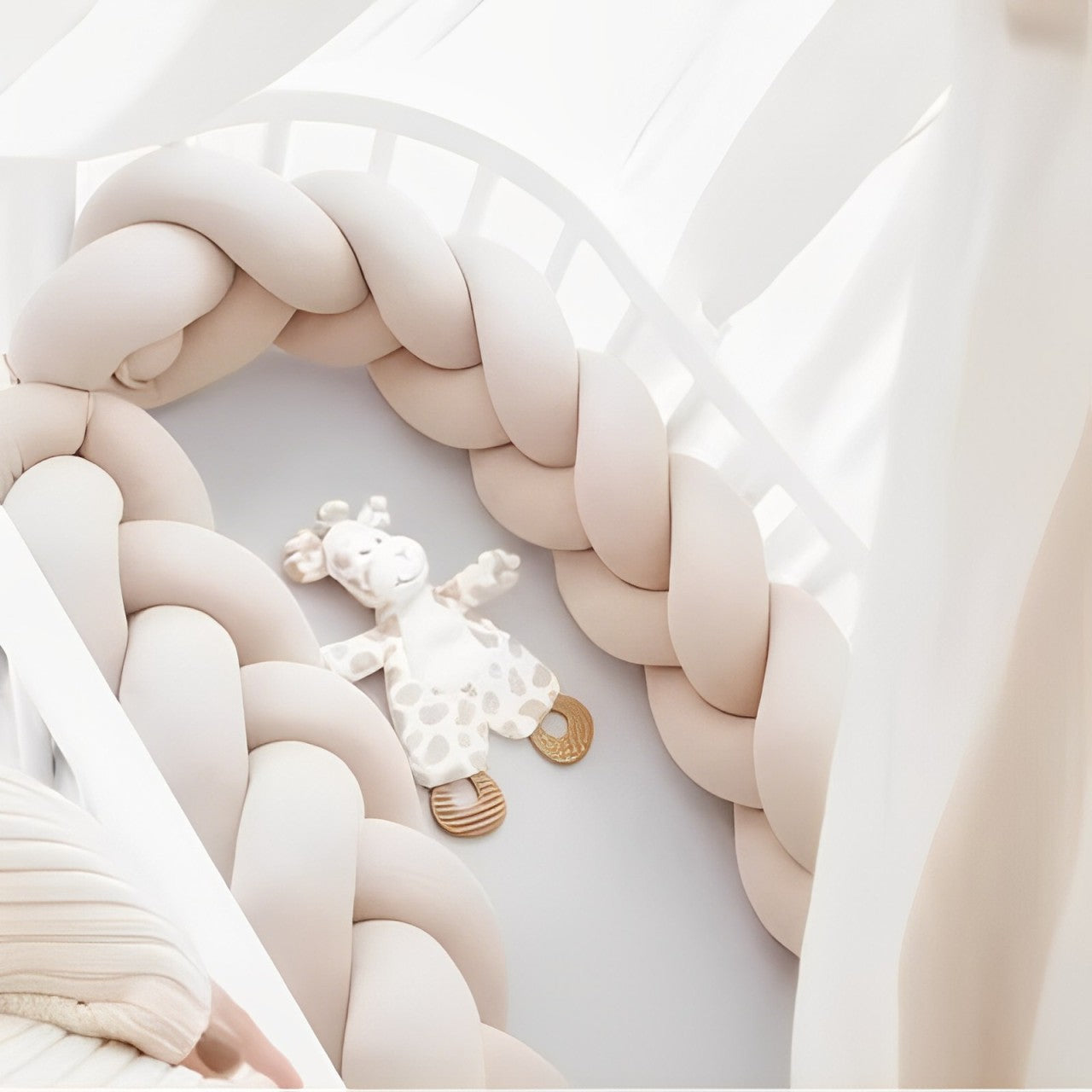 Tresse de lit universelle beige au touché doux, positionnée dans un lit à barreaux pour éviter les chocs et assurer une protection optimale.
