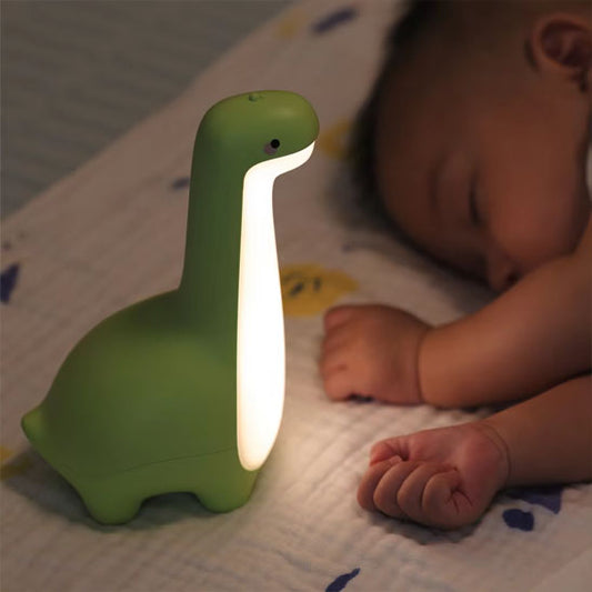 Veilleuse bebe USB dinosaure vert éclairant un bébé endormi