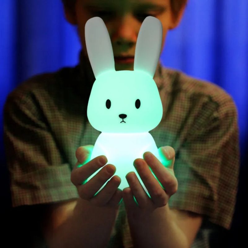 Veilleuse bébé lapin sans fil LED verte tenue par un enfant