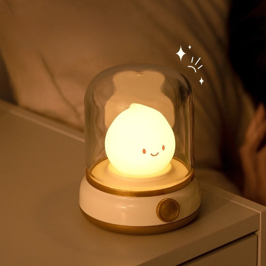 Veilleuse bébé rechargeable jaune posée sur une table de nuit